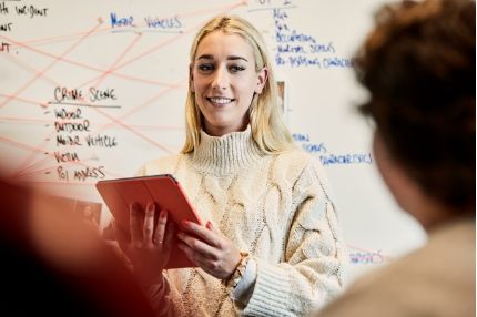 Woman speakin holding tablet
