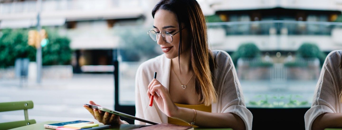 Woman working on tablet at cafe